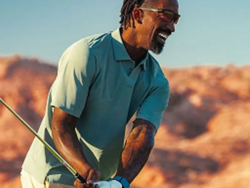 A golfer wearing Oakley sunglasses mid-swing