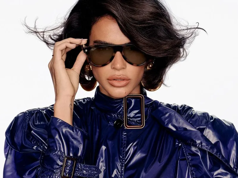 A woman adjusting her Ray-Ban Meta sunglasses