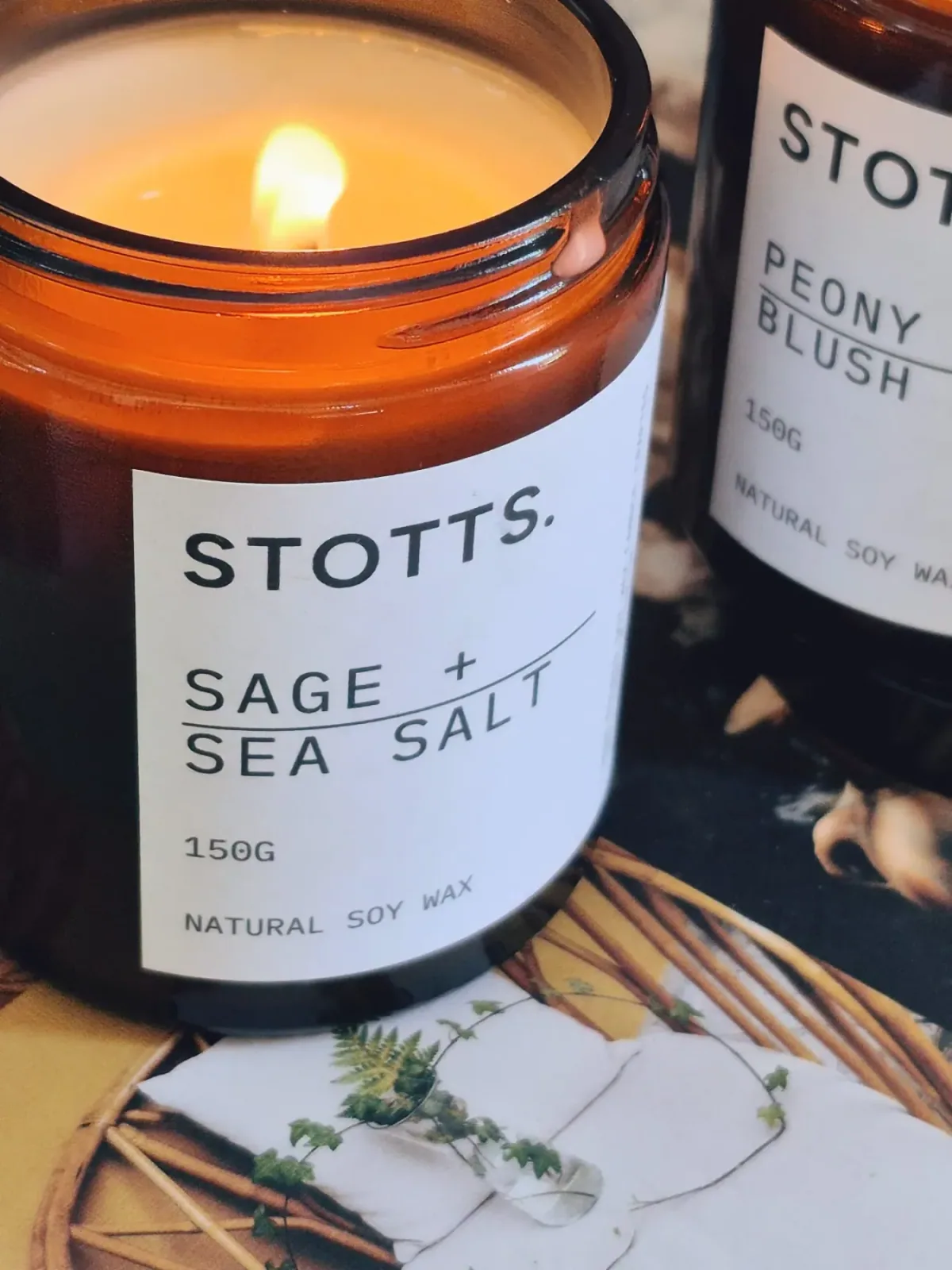 The sage and sea salt candle beside the peony one