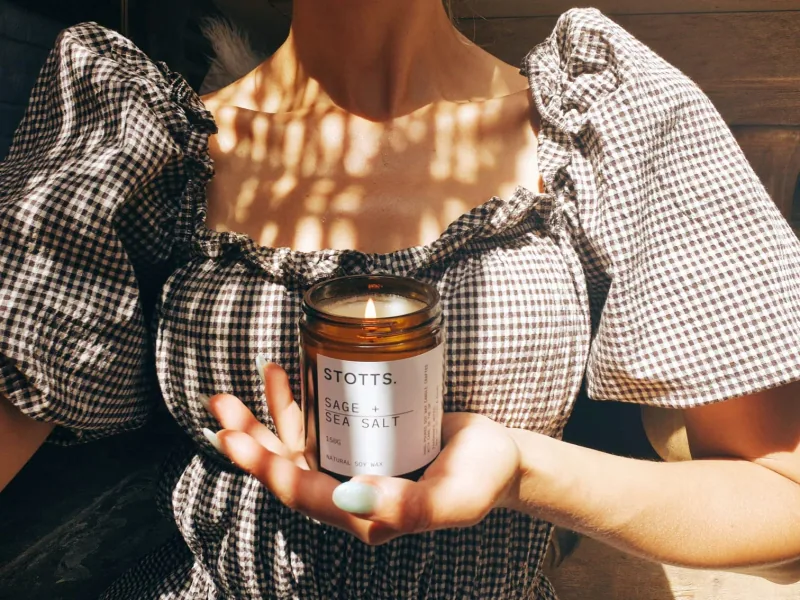 The sage and sea salt candle held in two hands
