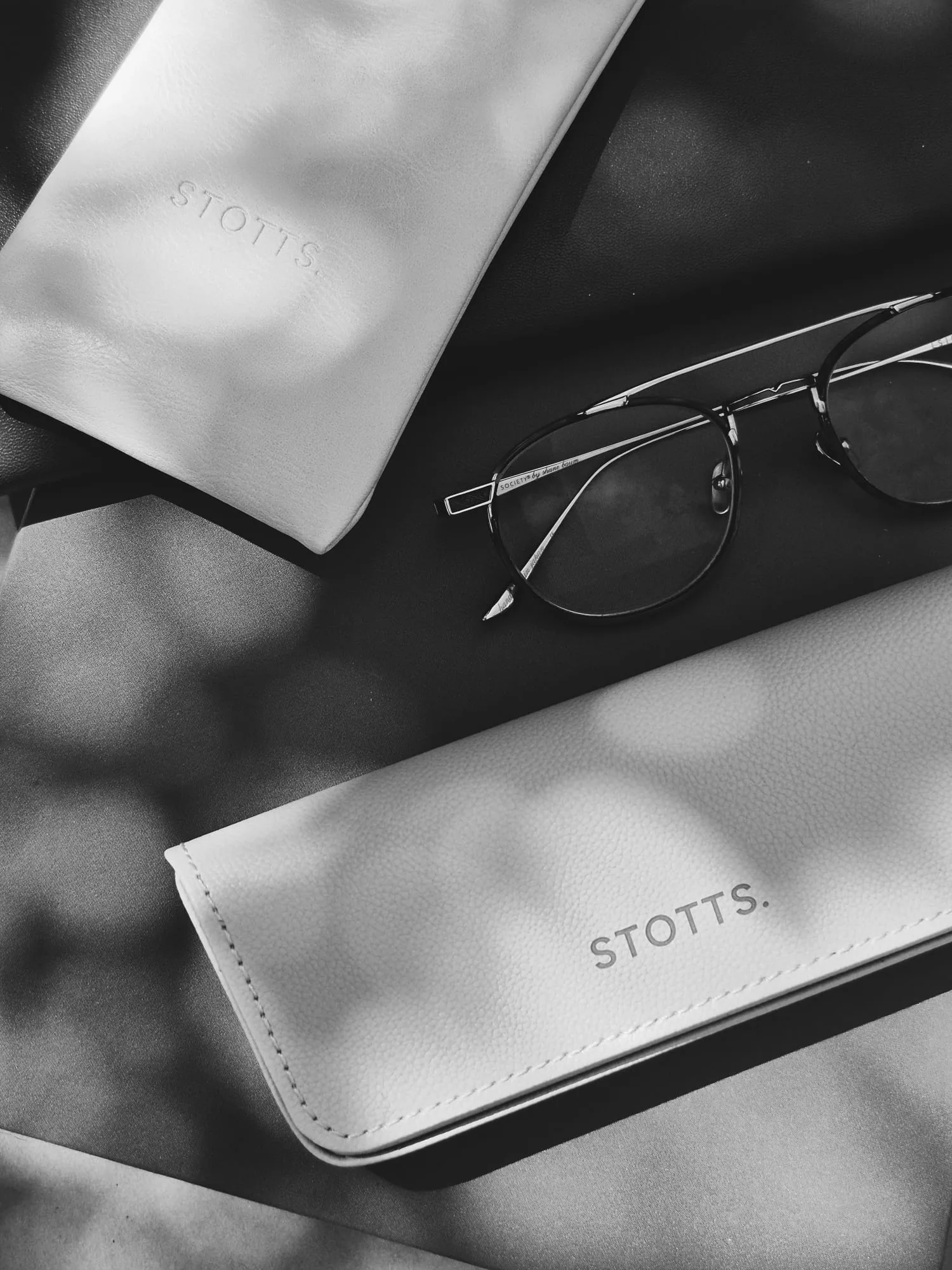 Black-and-white editorial shot of the STOTTS. Cream Blush eyewear case